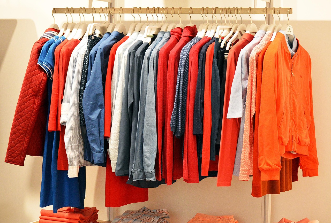 store, clothes, clothing, line, fashion, retail, clothing store, shop, shopping, consumer, purchase, department, orange, red, hangers, consumerism, spending, sale, customer, shopper, buy